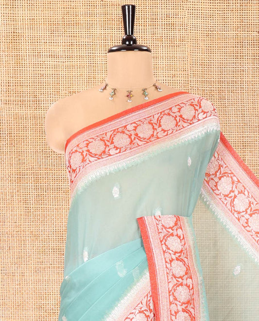 Turquoise Banaras Fancy Georgette Saree, Ornamented with Zari Buttas All Over Its Body, Complemented by a Contrast Floral Creeper Zari Border, Pallu Features Paisley Designs, and Paired with a Contrast Blouse