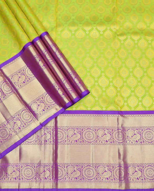 Green buttas silk half saree with contrast border of thilakam mokku, banaras, poo chkram, mayil design, zari design blouse & zari design border dhavani