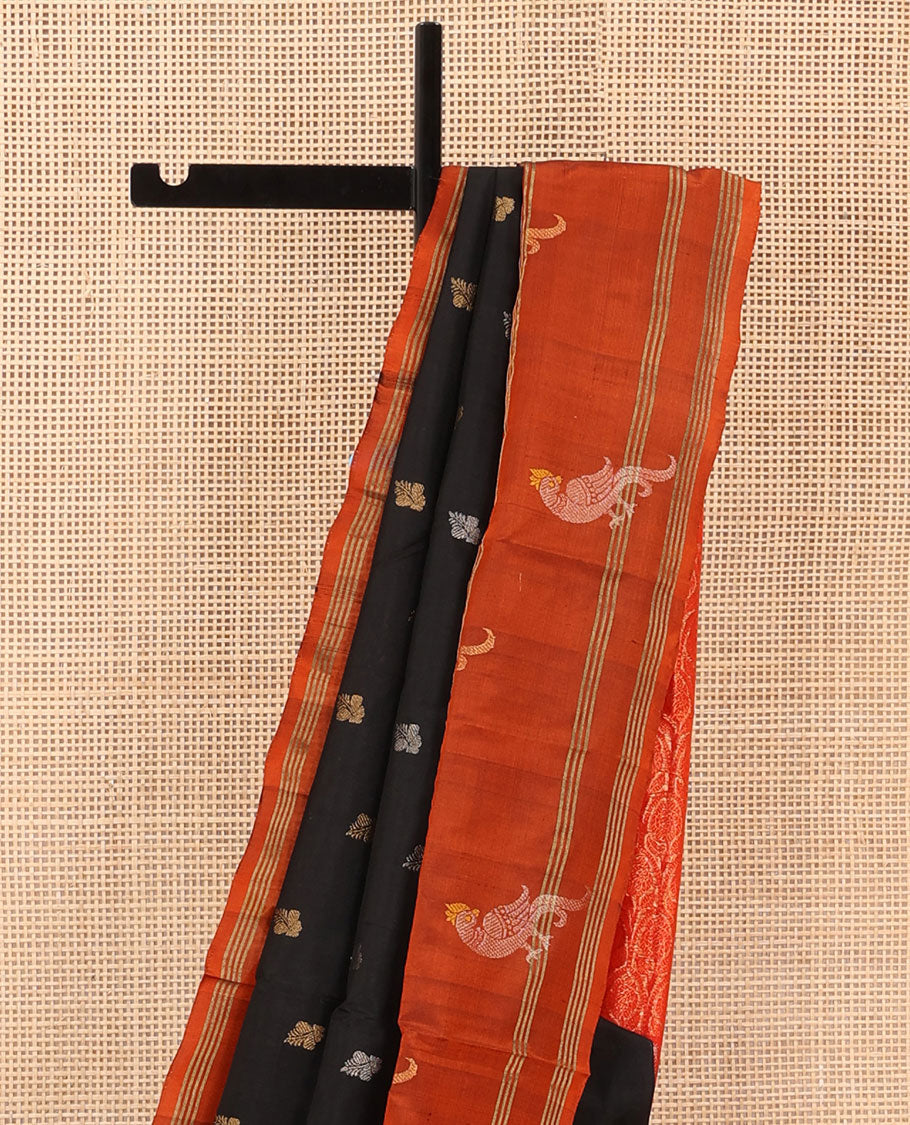 Inky Black Uppada Silk Saree Enlivened With Zari Buttas, Captivating Contrast Border Featuring Zari Stripes And Peacock Motifs, Pallu Depicting Rose Flower-Enclosed Mughal-Style Arches, And Paired With A Contrast Blouse