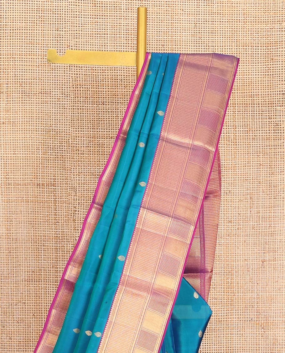 Blue Vasundhara Lite-Silk Mix Saree Highlighted with Zari Buttas on Its Body, Complemented by a Contrast Border of Thilakam Mokku, Ara Maadam, Vanki, and Then Kuli Kann Designs, Pallu Elevated with Jaal Designs, and Paired with a Contrast Blouse