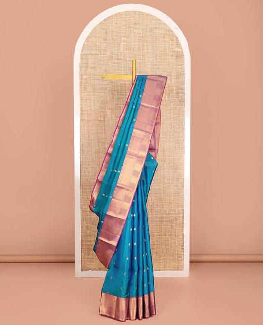 Blue Vasundhara Lite-Silk Mix Saree Highlighted with Zari Buttas on Its Body, Complemented by a Contrast Border of Thilakam Mokku, Ara Maadam, Vanki, and Then Kuli Kann Designs, Pallu Elevated with Jaal Designs, and Paired with a Contrast Blouse