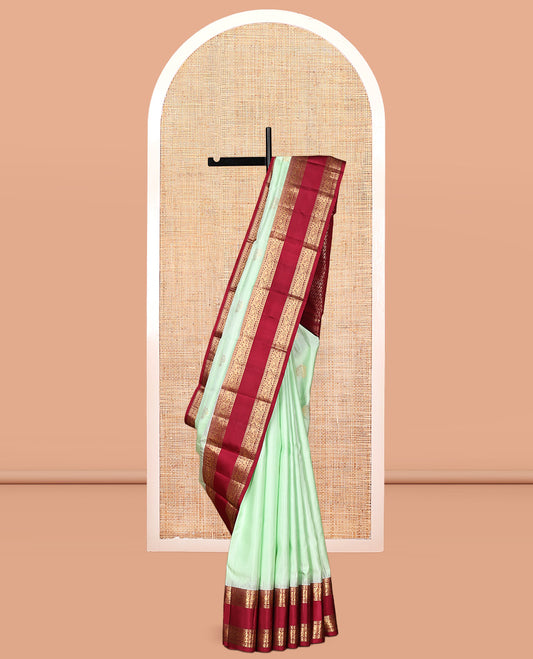 Green Zari Buttas Vasundhara Silk Saree Adorned with a Contrast Rettai Pettu Border of Rekku, Muthu, and Kodi Mayil Designs, Grand Pallu, and a Contrast Blouse