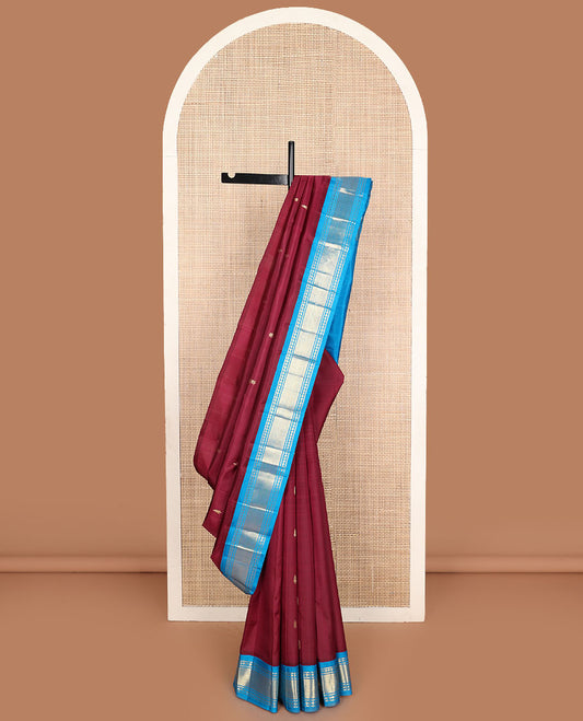 Maroon zari buttas Kanchipuram silk saree, contrast one-sided korvai border of lavangam, and mayil kann designs, and zari design pallu