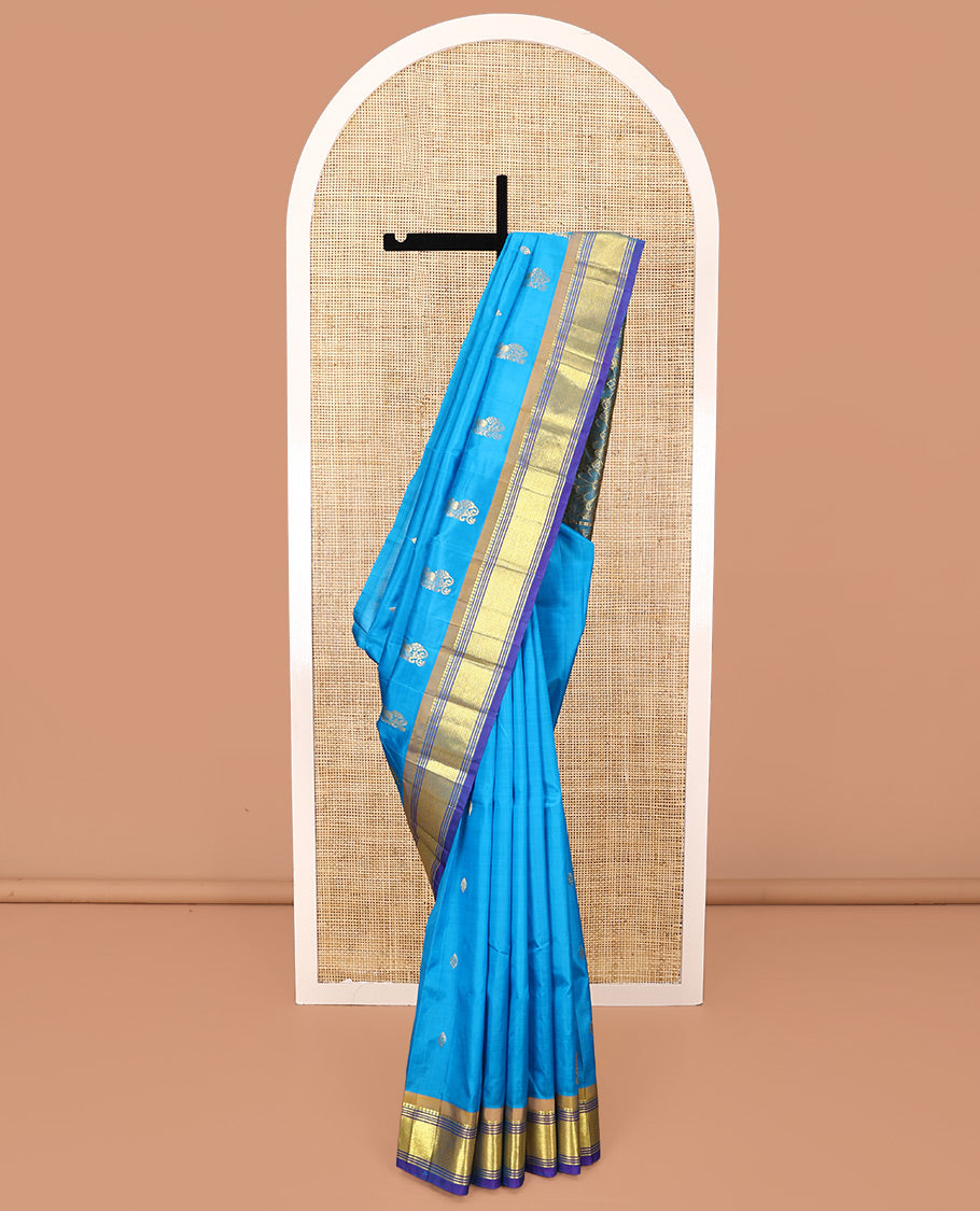 Blue Kanchipuram Silk Saree, Highlighted with Zari Buttas All Over Its Body, Complemented by a Contrast One-Sided Border of Panner Sombu, Banaras, Muthu, and Mayil Kann Designs, Pallu of Floral Designs, and Comes Without a Blouse