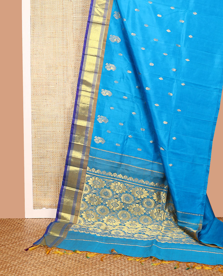 Blue Kanchipuram Silk Saree, Highlighted with Zari Buttas All Over Its Body, Complemented by a Contrast One-Sided Border of Panner Sombu, Banaras, Muthu, and Mayil Kann Designs, Pallu of Floral Designs, and Comes Without a Blouse