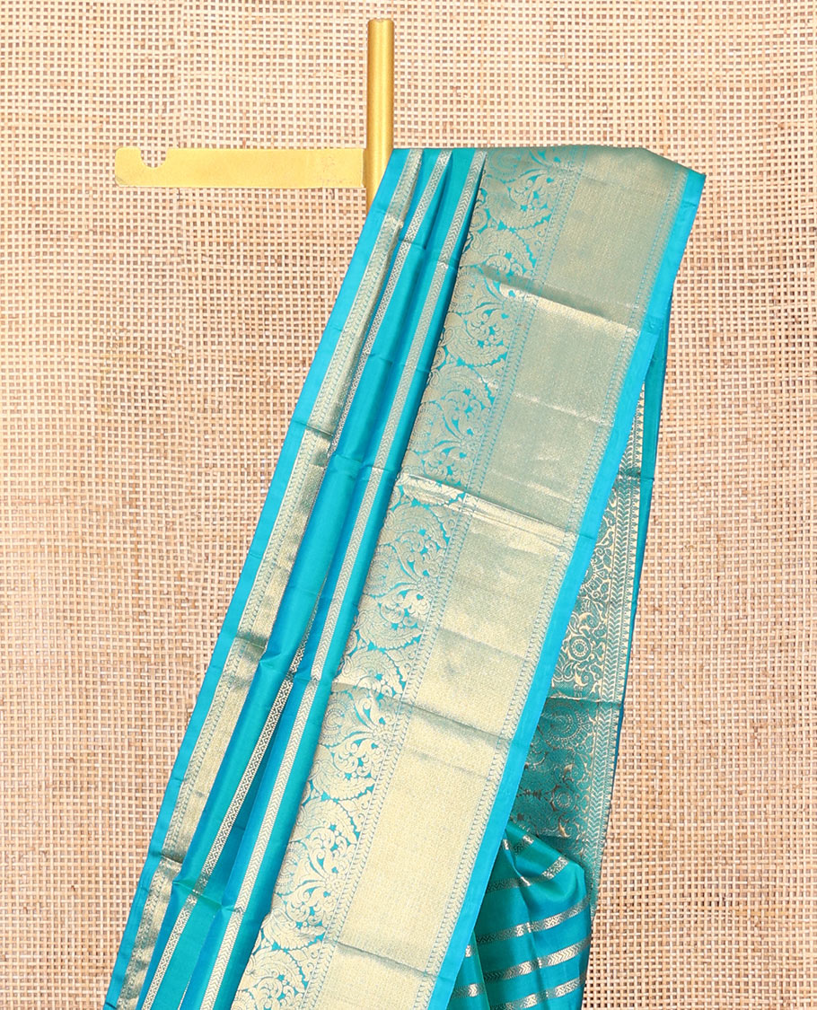 Blue Vasundhara Silk Saree, Gleamed Up with Muthu, and Neli Stripes, Complemented by a Zari Border of Thilakam, Kathir, Mayil, and Jaal Designs, Pallu Depicting Diagonal Stripes, and Paired with a Matching Blouse