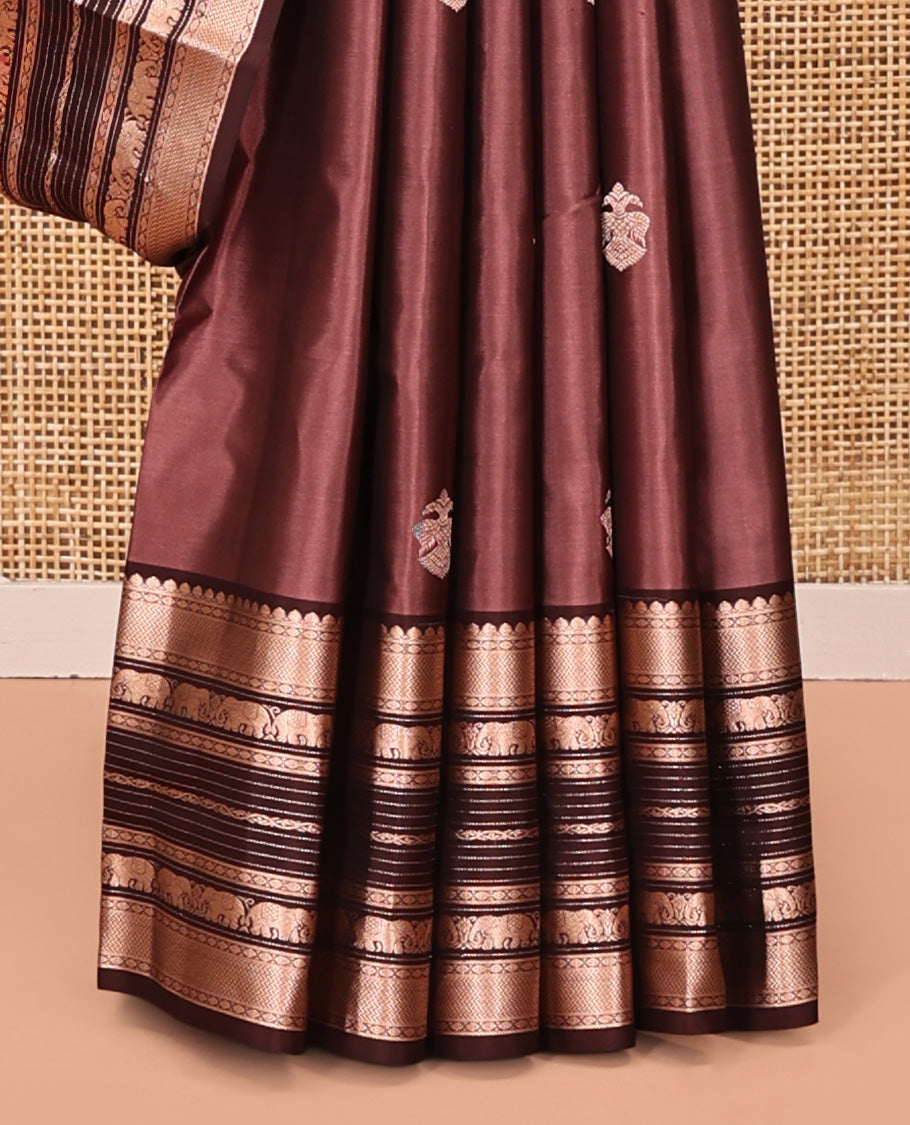 Brown Vasundhara Silk Saree, Detailed with Iruthakshi Buttas All Over Its Body, Complemented by a Contrast Border of Thilakam Mokku, Vanki, Yaanai, and Muthu Designs, Grand Pallu, and Paired with a Contrast Blouse