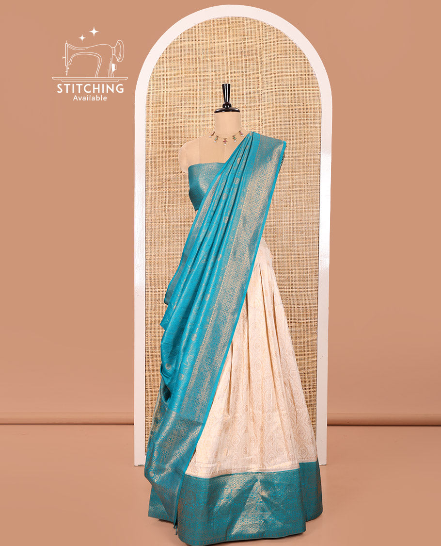 Cream and Blue Banaras Softy Half-Saree Featuring Jacquard Design All Over the Skirt, Decorated with a Contrast Geometric Zari Design Border, Paired with a Jacquard Blouse, and a Banaras Softy Dhavani with Floral Jaal Jacquard Design
