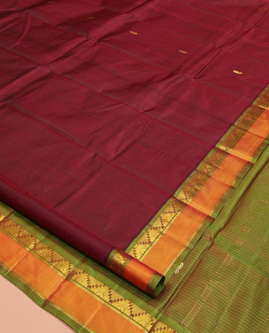 Maroon Kanchipuram Silk Saree, Sparsely Woven with Vazhaipoo Stripes and Buttas on Its Body, Complemented by Contrast Rettai Pettu Border of Thazampoo Rekku, and Kathir Designs, Zari-Striped Pallu, and Paired with a Contrast Blouse