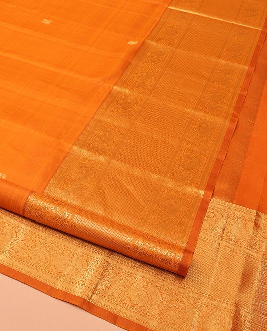 Orange Kanchipuram Silk Saree, Decked Up with Mayil Buttas All Over Its Body, Highlighted by Zari Border of Salngai, Mayil, Yaanai, and Mayil Kann Designs, Subtly Enriched Jaal Pallu, and Paired with a Matching Blouse