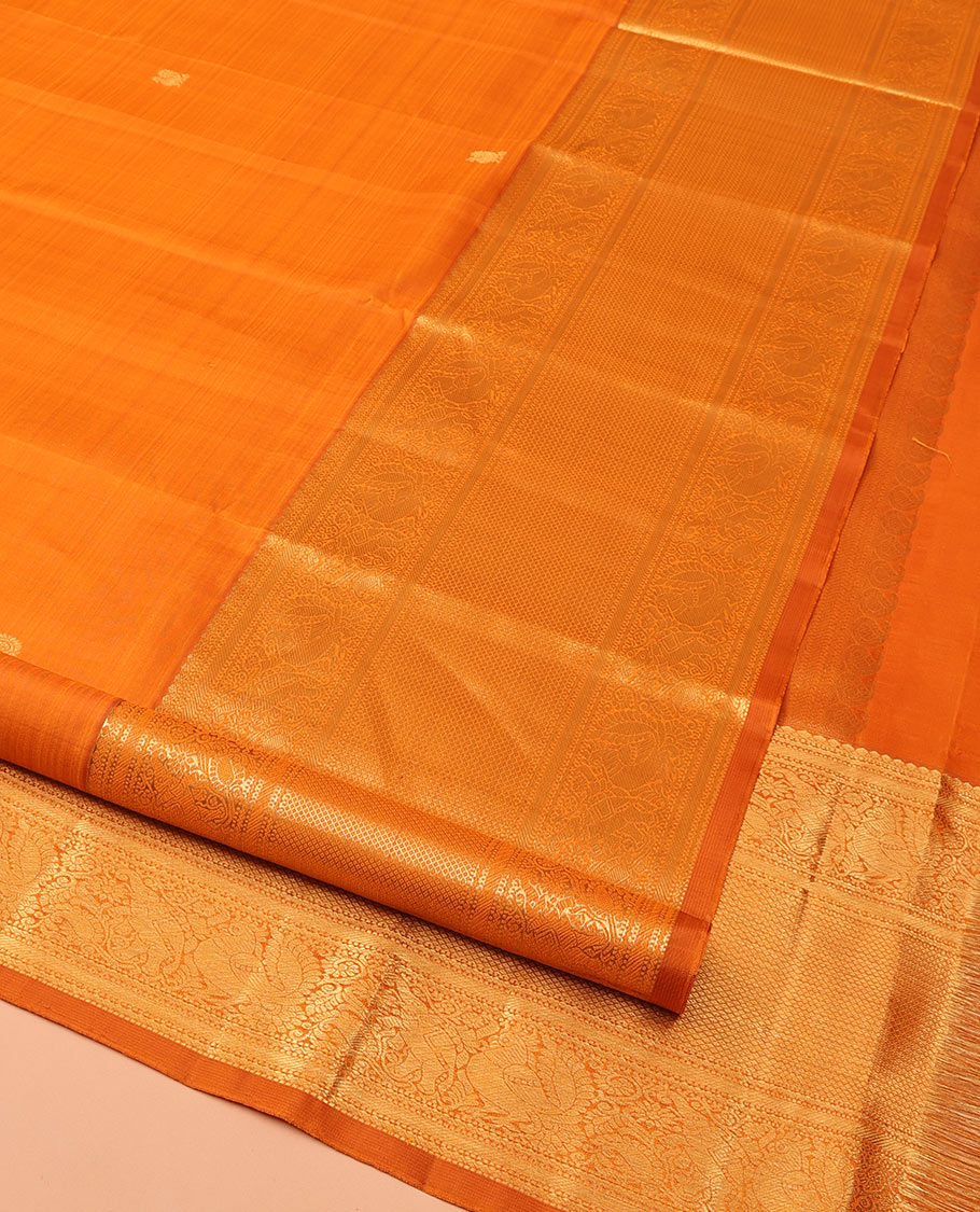 Orange Kanchipuram Silk Saree, Decked Up with Mayil Buttas All Over Its Body, Highlighted by Zari Border of Salngai, Mayil, Yaanai, and Mayil Kann Designs, Subtly Enriched Jaal Pallu, and Paired with a Matching Blouse