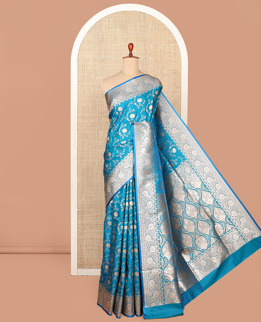 Blue Semi-Banaras Saree, Majestically Detailed with Floral Jaal Jacquard on Its Body, Highlighted by a Floral Creeper Design Border, Intricately Designed Zari Pallu, and Paired with a Matching Blouse