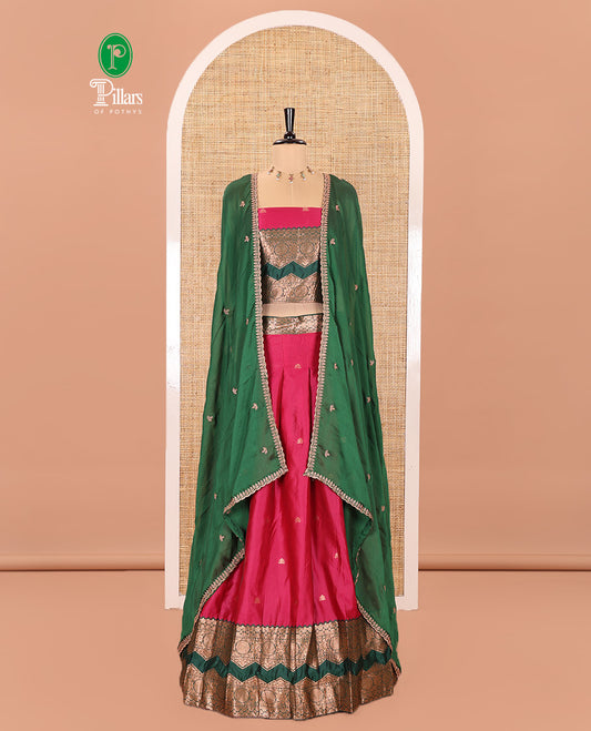 Pink and Green Semi-Banarasi Half-Saree Elevated with Zari Buttas on Its Skirt, Complemented by Contrast Traditional Zari Border of Chakram Designs, Paired with a Matching Blouse, and a Satin Georgette Embroidered Scallop Dhavani