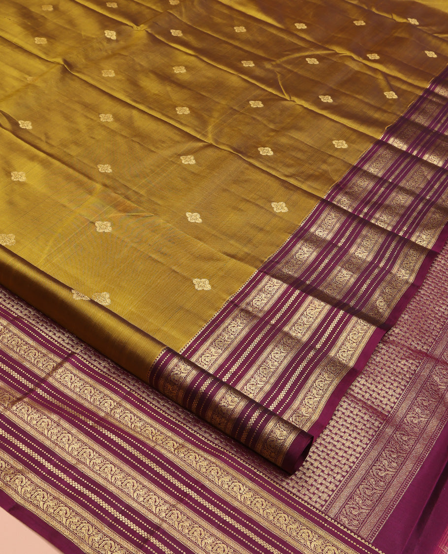 Green Vasundhara Silk Saree, Embellished with Zari Buttas All Over Its Body, Complemented by Contrast Border of Rekku, Muthu, Kathir, And Mayil Designs, Paiyadi Kattam Pallu, and Paired with a Contrast Blouse