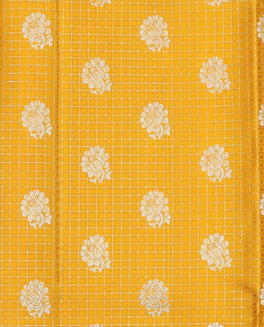 Yellow pure-silk half-saree with buttas, checks, and embossed design skirt, contrast traditional kanchi border, contrast zari design blouse, and a manga motifs woven dhavani