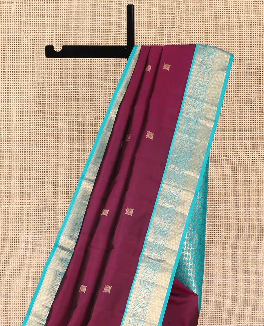 Wine Kanchipuram Silk Saree, Detailed with Zari Buttas on Its Body, Complemented by Contrast Border of Rekku, Muthu, Thilakam, and Mayil Kann Designs, Grandly Woven Pallu, and Paired with a Contrast Blouse