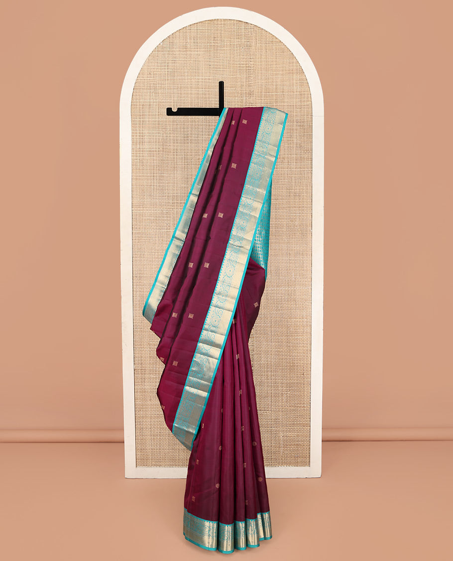 Wine Kanchipuram Silk Saree, Detailed with Zari Buttas on Its Body, Complemented by Contrast Border of Rekku, Muthu, Thilakam, and Mayil Kann Designs, Grandly Woven Pallu, and Paired with a Contrast Blouse