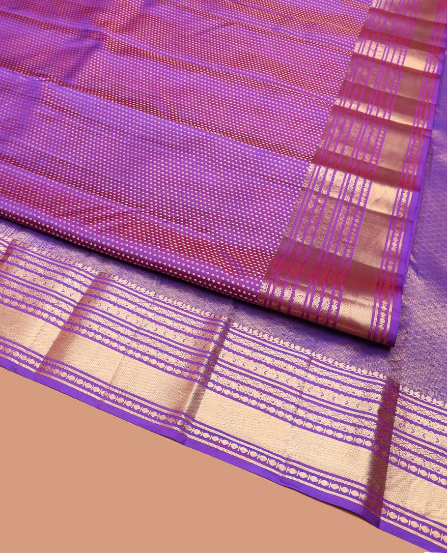 Violet Vasundhara Silk Saree, Gracefully Embellished with Zari Buttas on Its Body, Highlighted by Zari Border of Manga, Cross Kamalam, Jada Nagam, Rudraksham, and Mayil Kann Designs, Grand Jaal Pallu, and Paired with a Matching Blouse