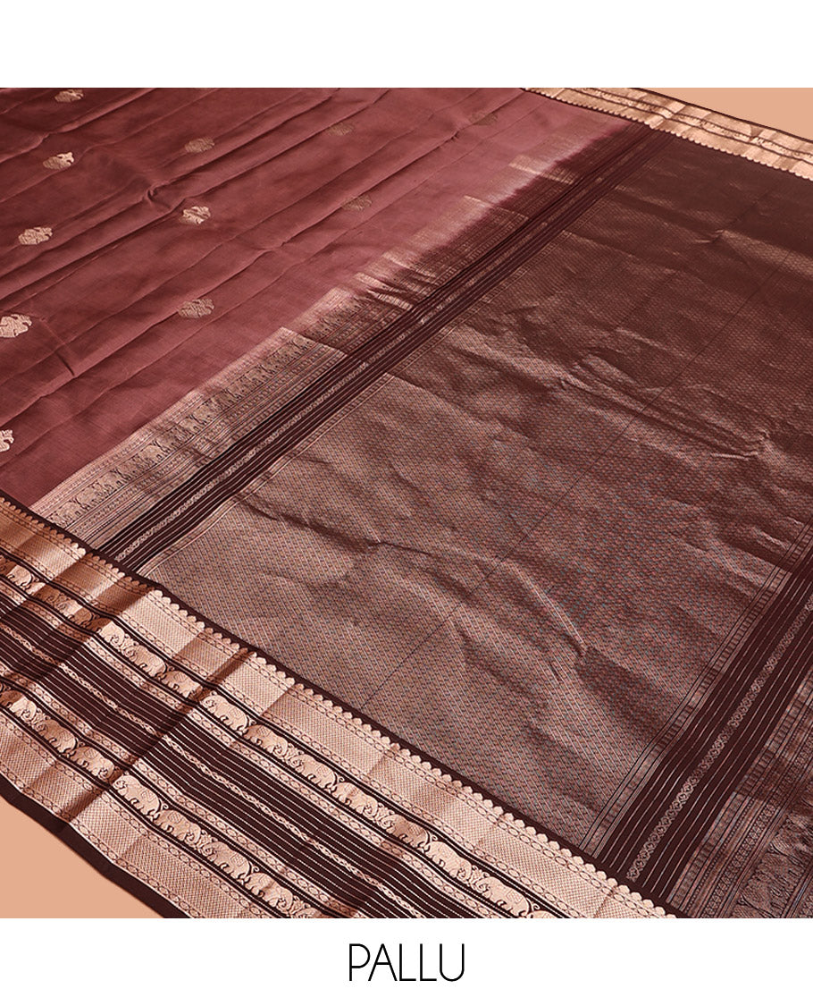 Brown Vasundhara Silk Saree, Detailed with Iruthakshi Buttas All Over Its Body, Complemented by a Contrast Border of Thilakam Mokku, Vanki, Yaanai, and Muthu Designs, Grand Pallu, and Paired with a Contrast Blouse
