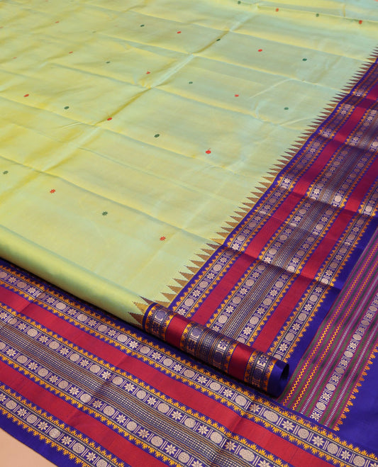 Green Kanchipuram Silk Saree, Beautifully Bedecked with Thread Buttas All Over Its Body, Complemented by a Contrast Border of Thazampoo Rekku, Muthu, Star Vanki, and Rudraksham Designs, Seppu Rekku Pallu, and Paired with a Contrast Blouse