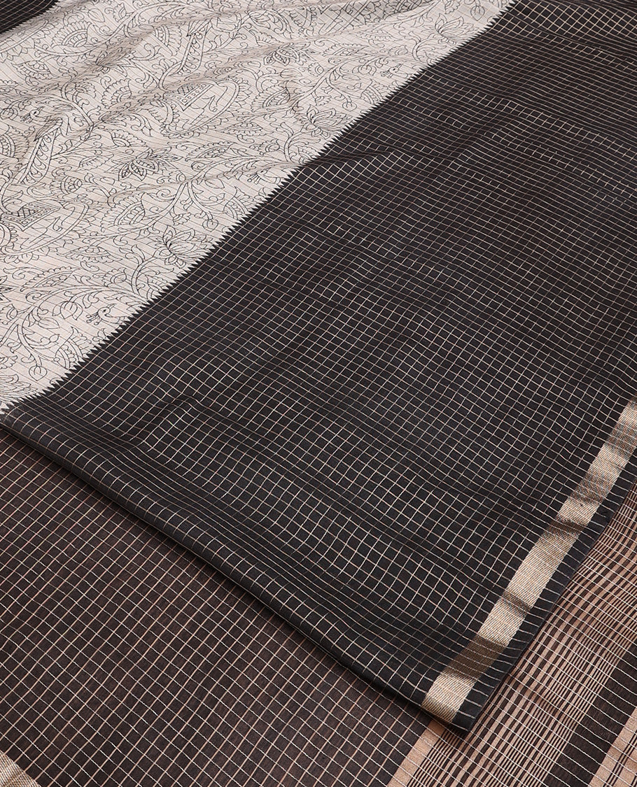 Black and beige half-and-half style Muga silk saree adorned with zari micro-checks, and kalamkari flora-fauna prints, zari piping border, and zari striped pallu