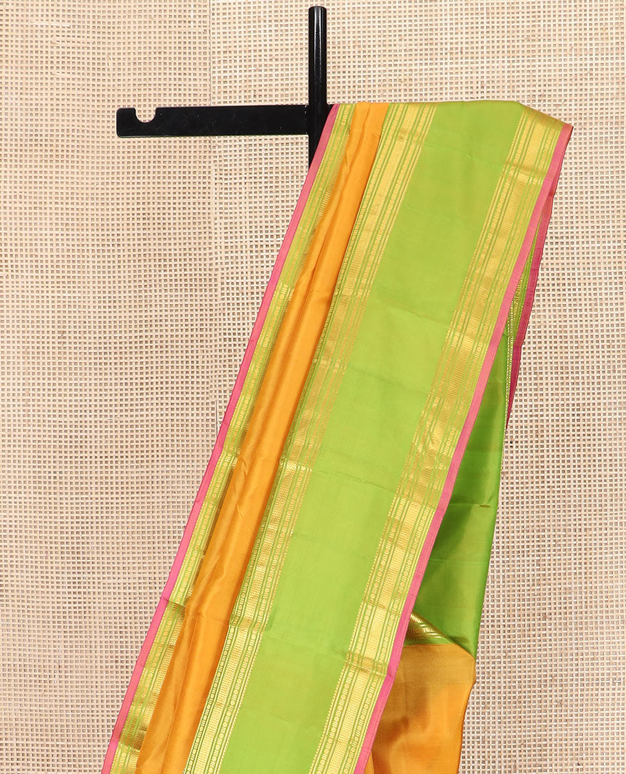 Orange Plain Kanchipuram Silk Saree Accentuated by a Contrast Rettai Pettu Border Featuring Rekku, Banaras, Rudraksham, and Vanki Designs, with a Subtly Zari-Woven Pallu, Paired with a Contrast Blouse