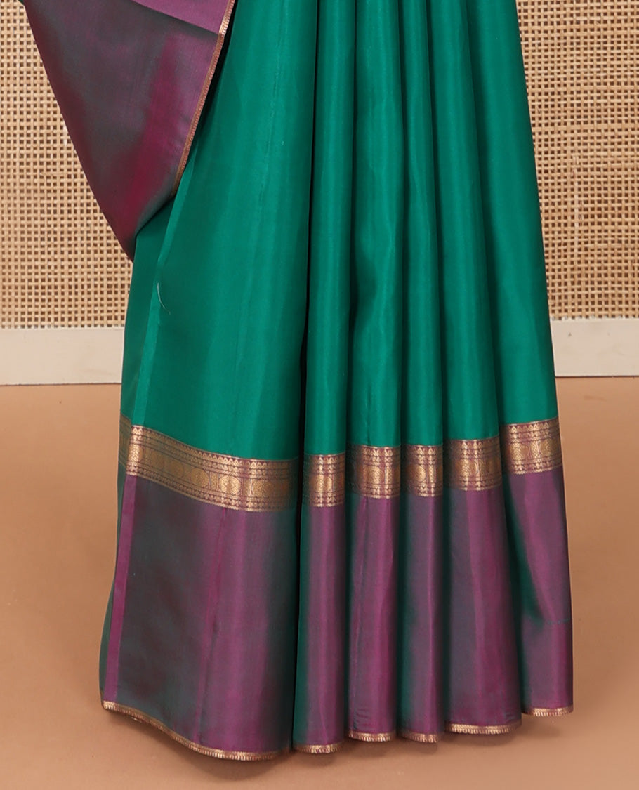 Green plain Kanchipuram silk saree, contrast ganga jamuna rettai pettu border of rekku, neli, banaras, and rudraksham designs, and pallu of kathir, rudraksham, neli, poun, ara bogudi, and ara maadam