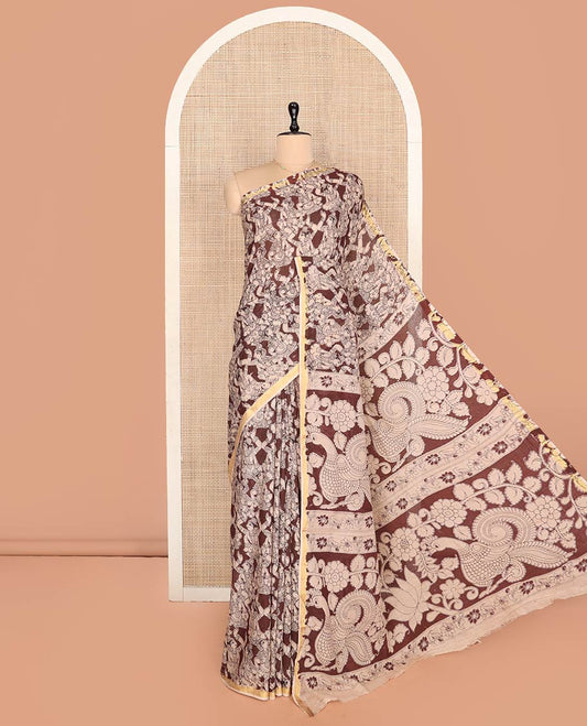 Brown Machine-Printed Kalamkari Cotton Saree Features Human Motifs, a Piping Border, Pallu of Peacocks, and a Matching Blouse