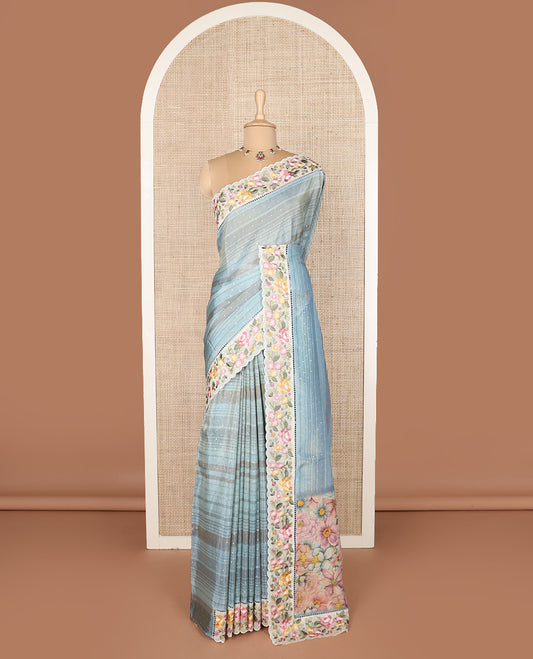 Pastel blue dobby-style buttas dola silk saree, contrast floral embroidered scallop border, and floral printed pallu
