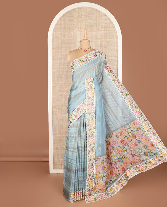 Pastel blue dobby-style buttas dola silk saree, contrast floral embroidered scallop border, and floral printed pallu