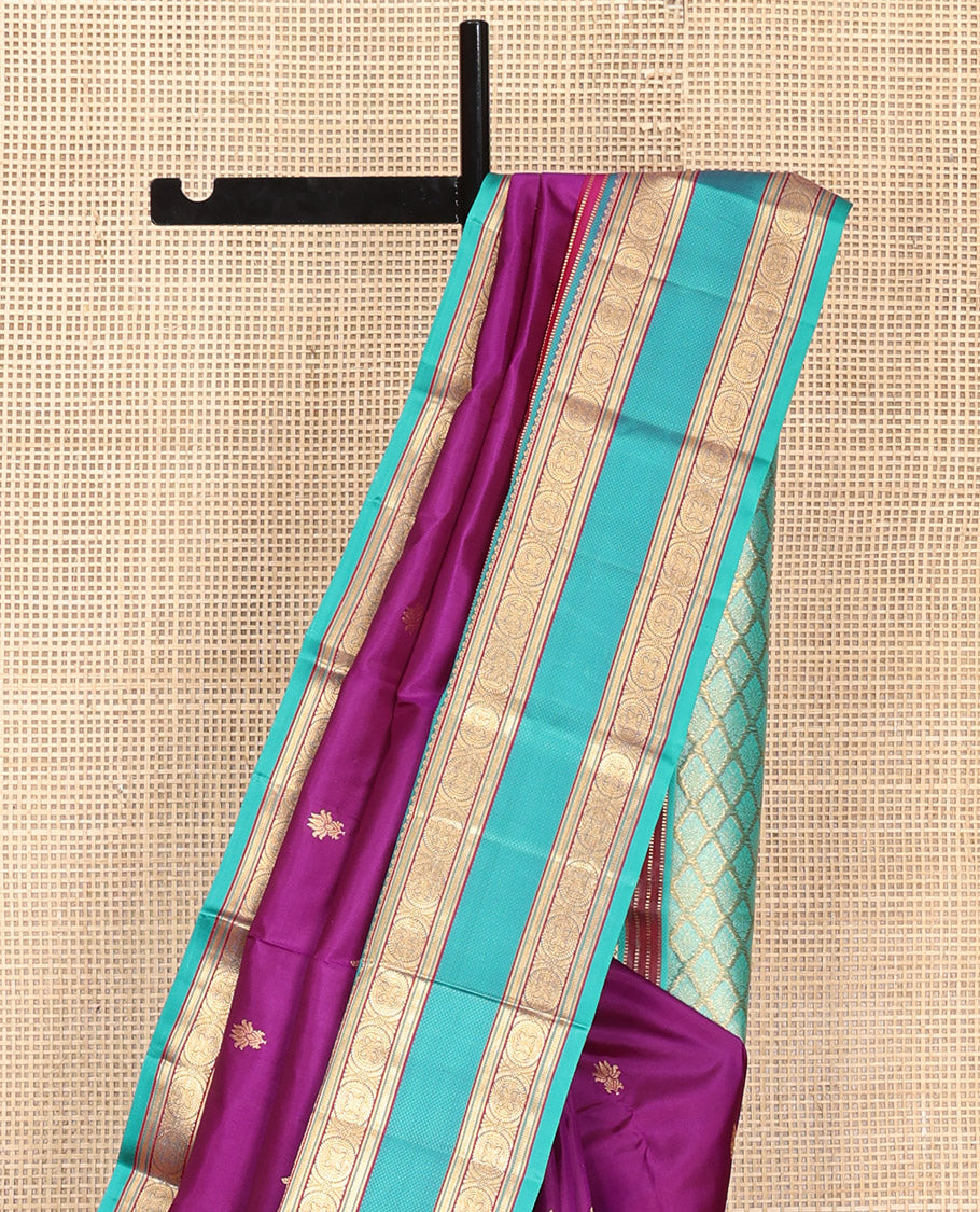 Purple Vasundhara Silk Saree, Beautifully Bedecked with Kamalam Buttas on Its Body, Complemented by a Captivating Contrast Border of Muthu, Chakram, and Mayil Kann Designs, Grand Jaal Pallu, and Paired with a Contrast Blouse