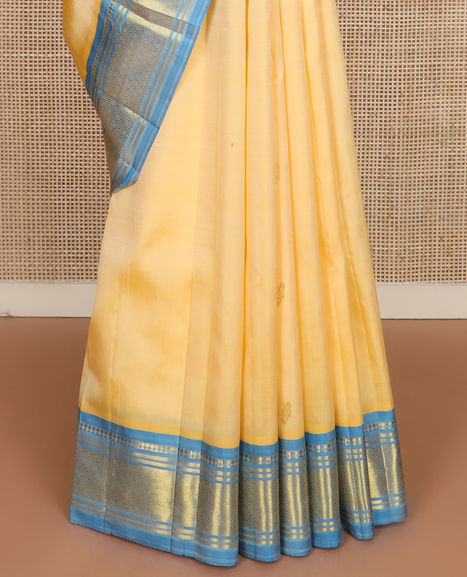 Yellow zari buttas Kanchipuram silk saree, contrast one-sided border of paneer sombu, banaras, and jaal design, and floral design pallu