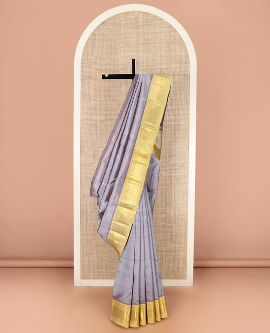 Grey Kanchipuram Silk Saree Detailed with Zari Buttas, Highlighted by Contrast One-Sided Border of Paneer Sombu, Banaras, and Jaal Designs, Pallu Accentuated with Floral Zari Design, and Comes Without a Blouse
