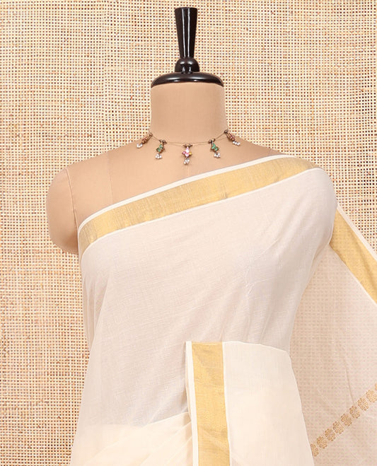 Cream Kerala Cotton Saree, Detailed with Zari Stripes All Over Its Body, a Subtle Bavanji Border, Pallu Features Peacock Designs, and Paired with a Matching Blouse