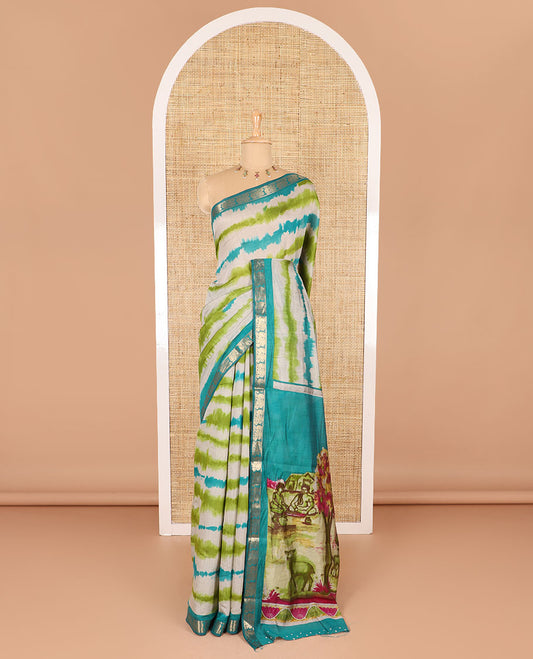 Green shibori printed muslin cotton saree, contrast peacock zari border, village scenery printed pallu, and a contrast polka dotted zari border blouse