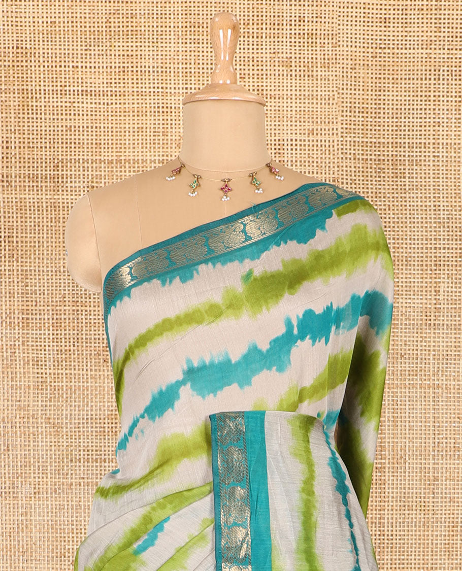 Green shibori printed muslin cotton saree, contrast peacock zari border, village scenery printed pallu, and a contrast polka dotted zari border blouse
