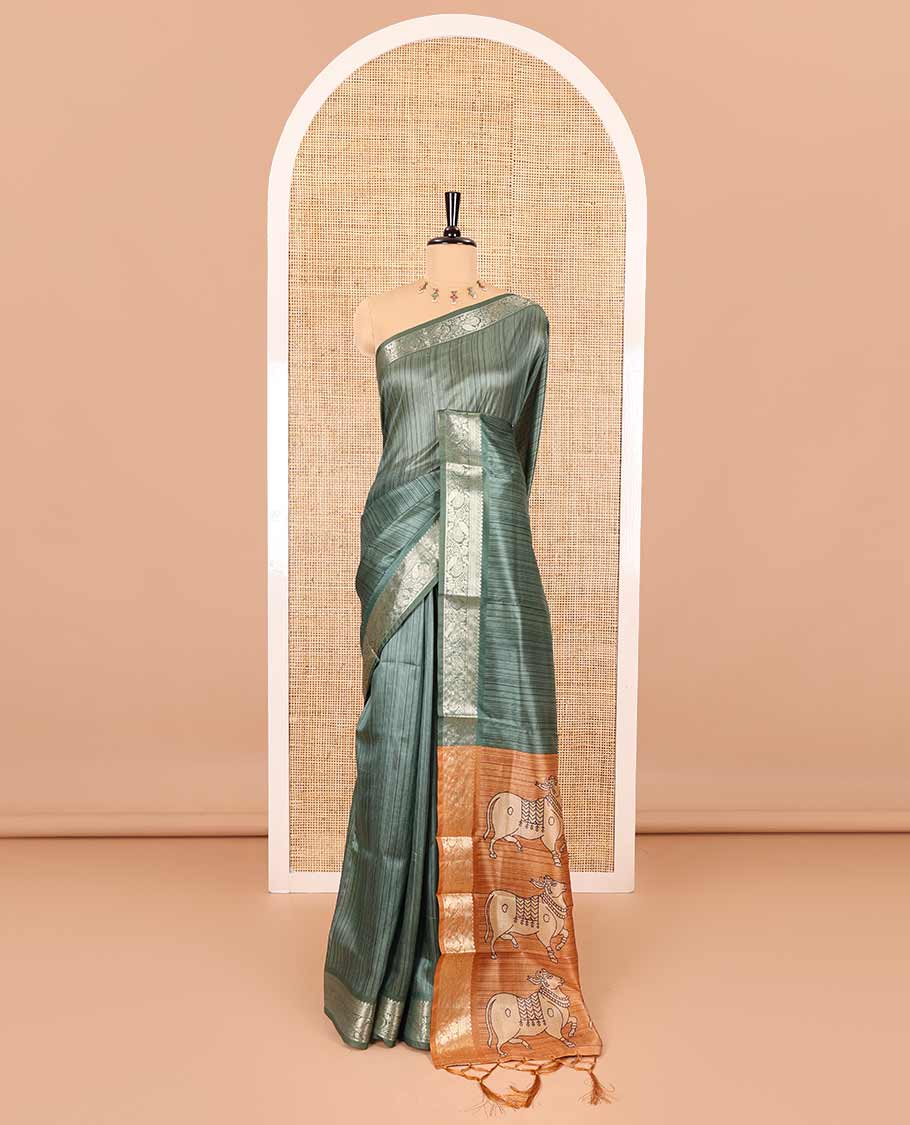 Green striped semi-tussar saree, traditional zari border of floral creeper designs, contrast pallu of Pichwai cow print, and contrast Pichwai cow printed blouse