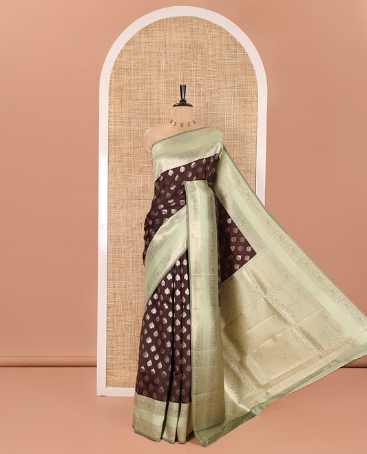 Brown and Green Kanchi Silk Saree, Gracefully Embellished with Zari Buttas All Over Its Body, Complemented by a Contrast Traditional Zari Rettai Pettu Border of Peacock-Chakram Designs, Intricately Designed Grand Pallu, and Paired with a Contrast Blouse