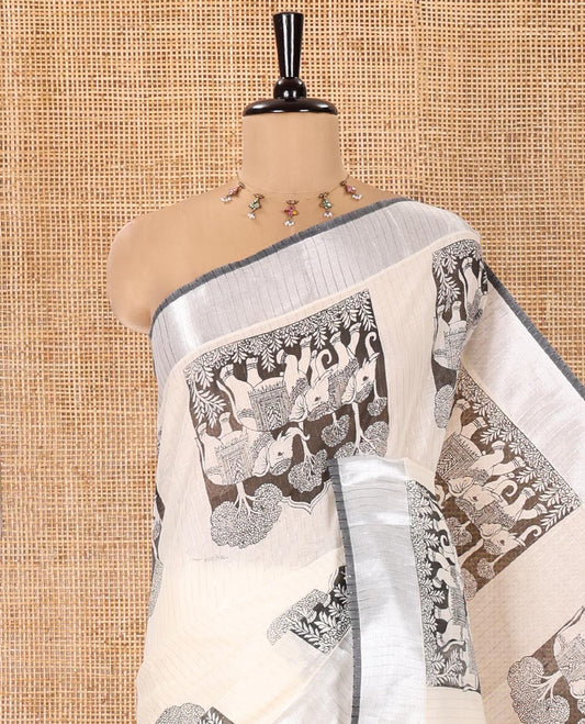 Half-White Kerala Cotton Saree, Artfully Detailed with Kalamkari-Style Elephant Motifs on Its Body, Highlighted by Zari Border, Pallu Pictures the Same Print, and Paired with a Matching Blouse