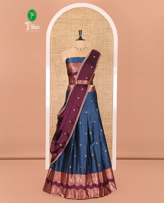 Peacock Blue and Purple Semi-Banarasi Half-Saree Elevated with Zari Buttas on Its Skirt, Complemented by Contrast Traditional Zari Border of Chakram Designs, Paired with a Matching Blouse, and a Satin Georgette Embroidered Scallop Dhavani