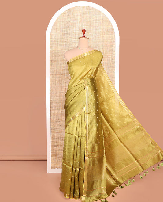 Green Banana Pith Saree Gracefully Embellished with Square-Shaped Zari Buttas, Subtly Woven Zari Piping Border, Pallu Gleamed Up with Zari Stripes, and Paired with a Matching Blouse
