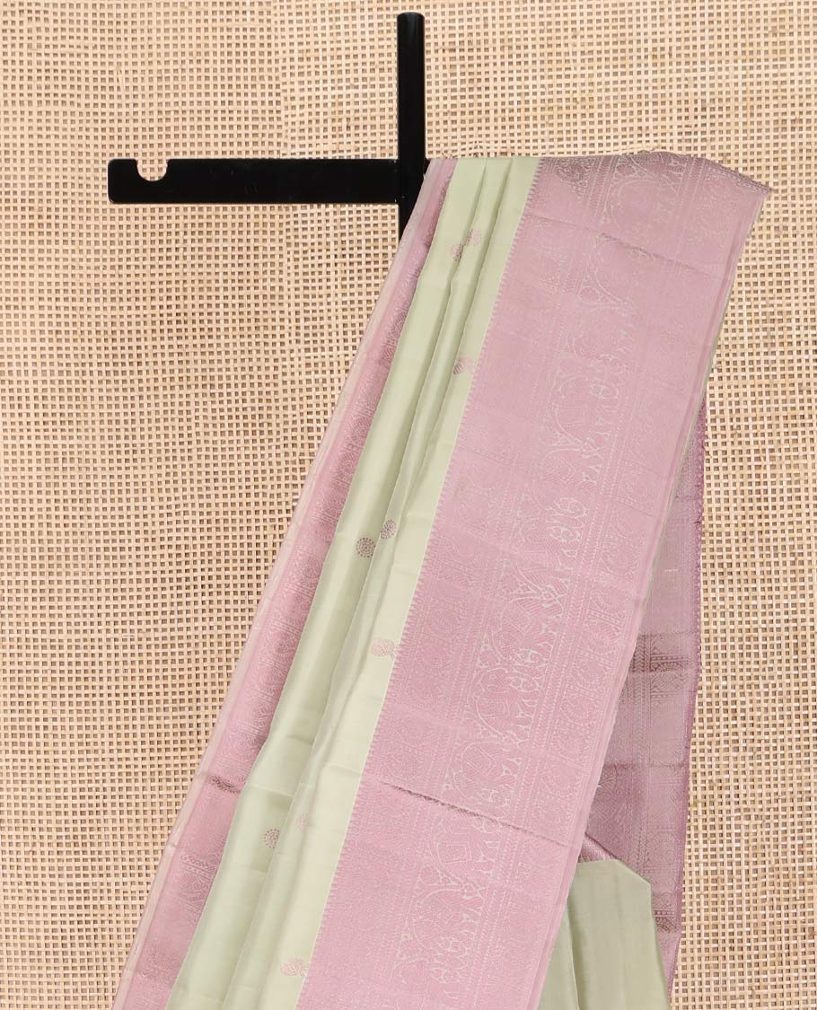 Green Kanchipuram Silk Saree, Subtly Enriched with Mayil-Chakram Buttas All Over Its Body, Complemented by a Contrast Border of Thilakam, Banaras, Mayil, Kathir, and Yaanai Designs, Pallu Steeped with Kamalam Designs, and Paired with a Contrast Blouse
