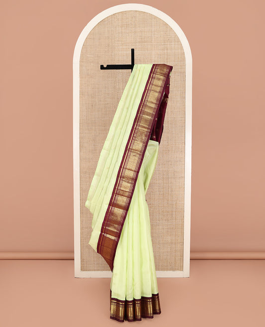 Light Green Kanchipuram Silk Saree, Delicately Woven with Zari Buttas on Its Body, Complemented by a Contrast One-Sided Border of Salngai, Banaras, Muthu, and Jaal Designs, Pallu of Zari Designs, and Comes Without a Blouse