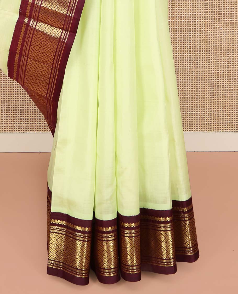 Light Green Kanchipuram Silk Saree, Delicately Woven with Zari Buttas on Its Body, Complemented by a Contrast One-Sided Border of Salngai, Banaras, Muthu, and Jaal Designs, Pallu of Zari Designs, and Comes Without a Blouse