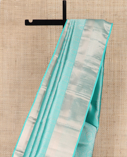 Blue Kanchipuram Wedding Silk Saree Subtly Sparkled with Jacquard Designs, Highlighted with Zari Border of Thilakam Mokku, Banaras, and Mayil Kann Designs, Grandly Zari Woven Pallu, and Paired with a Matching Blouse