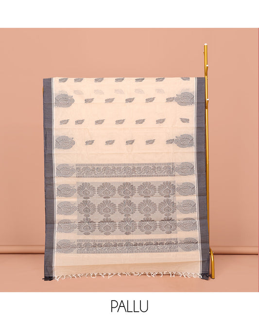 Cream Kanchi Cotton Saree, Embellished with Leaf Buttas All Over Its Body, Complemented by Contrast Border, Pallu of Intricate Designs, and Paired with a Matching Blouse
