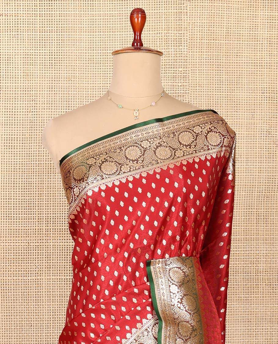 Red Semi-Banaras Saree, Richly Detailed with Zari Buttas on Its Body, Complemented by a Contrast Floral -Paisley Creeper Design Border, Intricately Designed Pallu, and Paired with a Contrast Blouse
