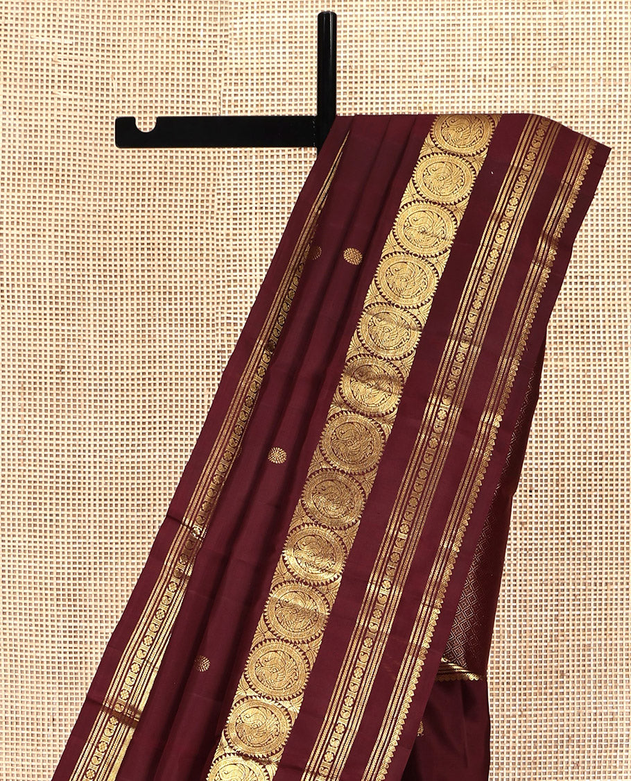 Maroon Kanchipuram Silk Saree, Crafted with Mayil and Chakram Buttas All Over Its Body, Highlighted by a Zari Border of Thilakam Mokku, Kathir, Kamalam, Manga, and Round Mayil Designs, Grand Jaal Pallu, and Paired with a Matching Blouse