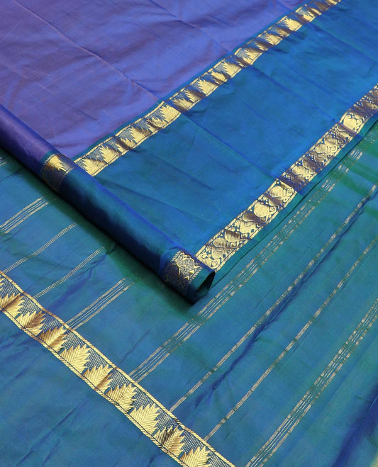 Blue plain Kanchipuram silk saree, contrast rettai pettu border of thazampoo rekku, manga, and mayil designs, and zari striped pallu