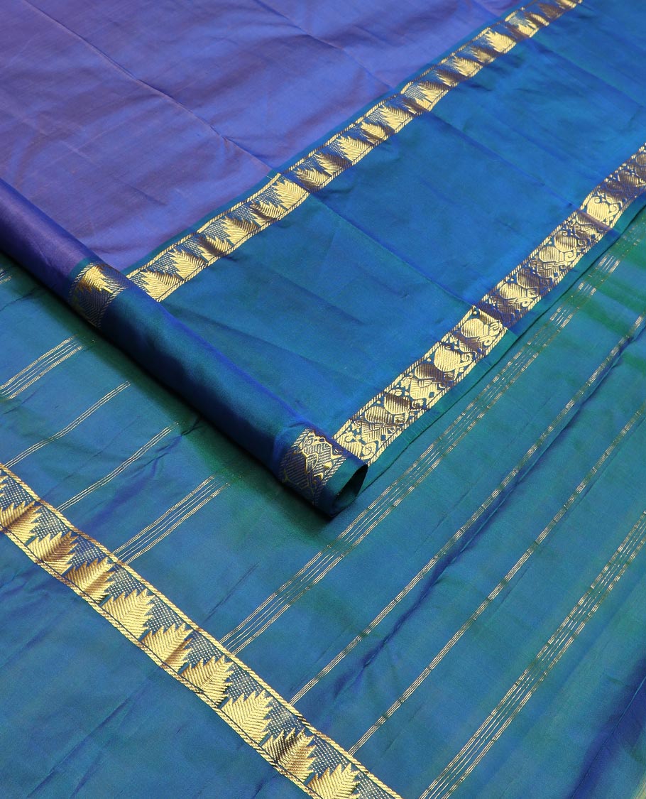 Blue plain Kanchipuram silk saree, contrast rettai pettu border of thazampoo rekku, manga, and mayil designs, and zari striped pallu